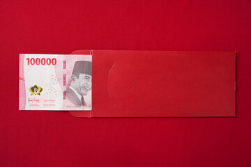 Lucky Indonesian chinese woman opening a red envelope gift, find large amount of money inside, one...