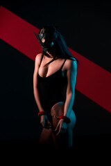 Portrait of a Sexy Woman in a Cat Mask With Handcuffs in a Neon-Lit Setting Focused on BDSM Themes