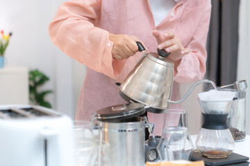 Asian young woman enjoying bread and coffee for breakfast at home, morning routine before work