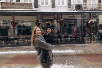 Happy mother and daughter on the streets of a winter city