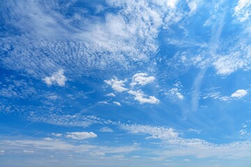 Fototapeta premium This captivating blue sky features fluffy white clouds scattered across a bright sunny day, creating a picturesque scene for nature lovers and outdoor enthusiasts.