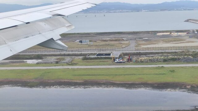 Plane landing at Osaka Kansai International Airport airplane wing window view 4k footage