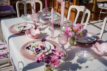Experience an exquisite pink and white floral themed place setting in Brugge, Belgium, featuring beautiful plates, cups, and fresh flowers, perfect for memorable events and gatherings.