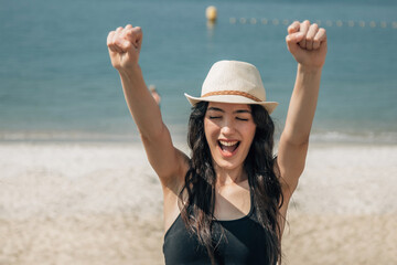 Woman in hat happy on the beach, happy pretty young woman on vacation, vacation concept