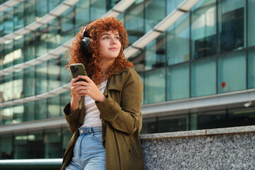 Woman listening to music with headphones in modern city