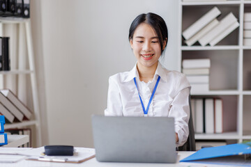 Business asian woman work on laptop sitting at desk in bright office, working and smiling Financial and Accounting concept.