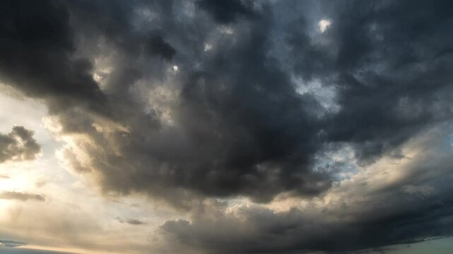 storm sky timelapse - dark dramatic clouds during thunderstorm, rain and wind, extreme weather, abstract background 