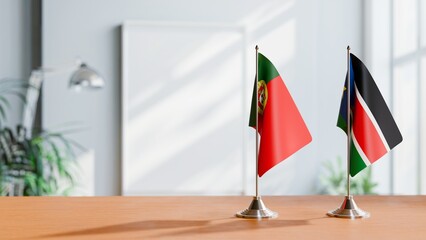 FLAGS OF PORTUGAL AND SOUTH SUDAN ON TABLE