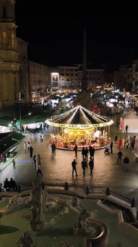 La giostra di Piazza Navona, icona del natale e dell'epifania a Roma, Italia. 
Vista aerea delle bancarelle e dalla giostra di piazza Navona allestita a natale 2024. 