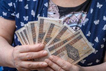 Polskie pieniądze wachlarz gotówki pln z bliska w dłoniach seniorki