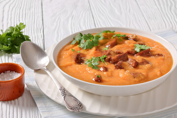 creamy carrot beef soup in a white bowl