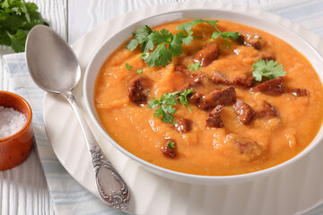 creamy carrot beef soup in a white bowl