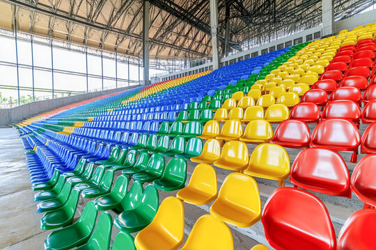 Empty multicolored seats in a stadium creating a rainbow pattern