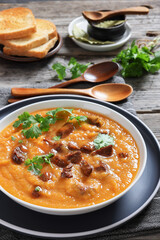creamy carrot beef soup in a white bowl