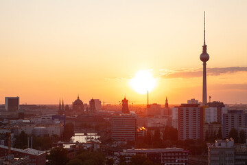 Ausblick auf Berlin mit der untergehenden Sonne am Horizont und der Berliner Fernsehturm Alex, das...