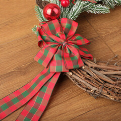 Christmas wreath over wooden background, closeup view. Xmas decoration.