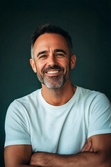 Obraz premium Portrait of a smiling mature man with crossed arms against dark background