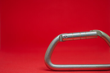 Climbing carabiner on a red background close-up, selective focus