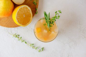 Pear drink cocktail with lemon, rosemary, thyme and ice in a glass on a white background. Healthy drink, sugar and alcohol free. Top view.