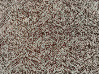 Close up of upholstery fabric in chevron pattern, in beige brown color. Inverted v shape chevron pattern seamless background texture.