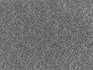 Close up of upholstery fabric in chevron pattern, in grey and black color. Inverted v shape chevron pattern seamless background texture.