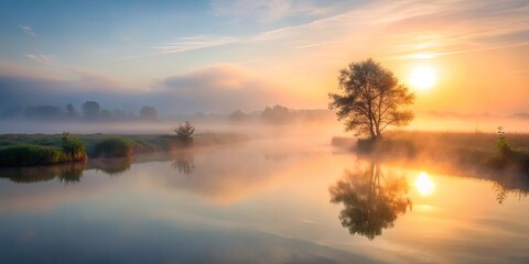 Obraz premium Serene Sunrise Over Foggy River With Solitary Tree Reflection