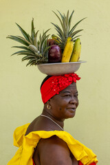 Woman Wearing A Colorful Traditional Colombian Dress Balancing Fruits On Her Head