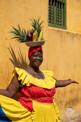 Woman Wearing A Colorful Traditional Colombian Dress Balancing Fruits On Her Head