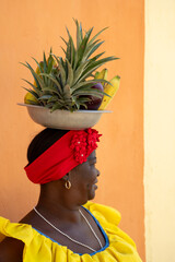 Woman Wearing A Colorful Traditional Colombian Dress Balancing Fruits On Her Head