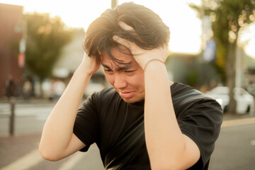 頭を抱えて落ち込む男性