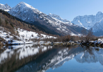 Dombay, Karachay-Cherkessia. Teberda National Park. Lake Tumanly-Gel or Tumanly-Kol (Misty Lake) is in valley of Gonachkhir River. Snowy peaks of Mount Chotcha are reflected in lake as in mirror.