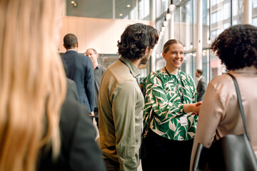 Group of male and female business delegates interacting with each other during event at convention center