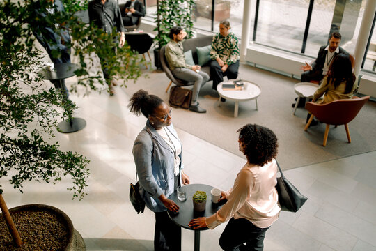 High angle view of businesswomen discussing in lobby at convention center