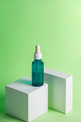 Blue glass cosmetic bottle, Skin care or sunscreen cosmetic with stylish props on black background.