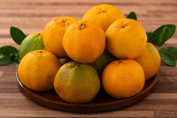 Fresh juicy tangerine mandarin orange on wooden table background.
