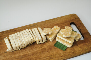 Raw tempeh that has been cut on a cutting board