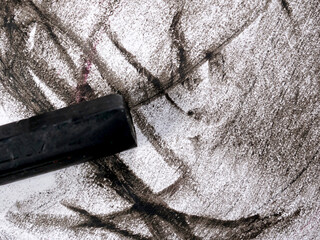 used and broken  crayon on black and white painted paper background