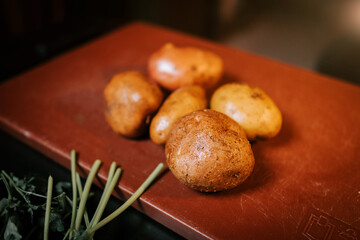 Ripe Potatoes Arranged on a Wooden Board in a Cozy Kitchen Setting, Perfect for Cooking and Meal Preparation