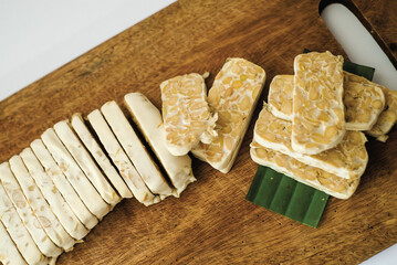 Raw tempeh that has been cut on a cutting board