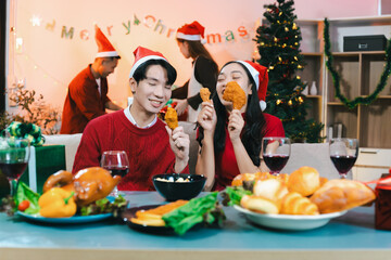 drinks and conversation, people celebrating together at Merry Christmas and Happy New Year. Friends are happy and celebrating with food, wine and friendship of love and gift exchange at the event.