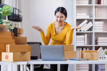 Portrait of Asian young woman SME working with a box at workplace. start-up small business owner, small business entrepreneur SME or freelance business online and delivery concept.
