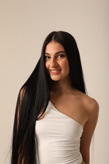 Close-up of beautiful woman with long dark hair and cute smile looking at the camera. Mock-up.