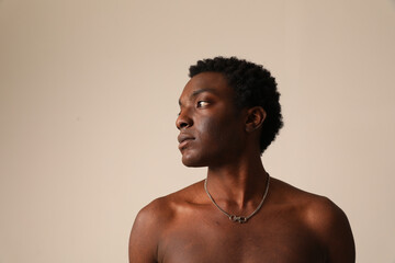 Profile portrait of young African American man posing over light background. Vertical mock-up.