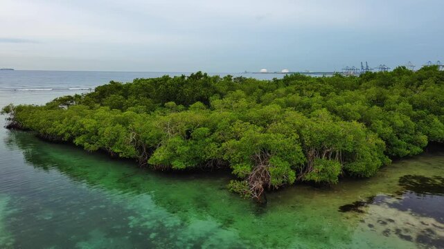 La Matica islet, mangrove forest, Playa Boca Chica beach, Caucedo port in background, Santo Domingo in Dominican Republic. Aerial sideways at low altitude