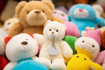 Blank Matte White Keychain Resting in a Pile of Soft Plush Toys