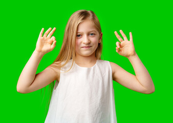 Young girl expressing positivity with hand gestures against a vibrant green background