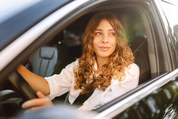 Young woman driving vehicle confidently, seatbelt. Automobile travel.