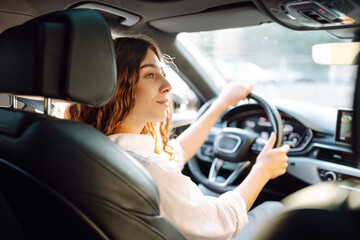 Young woman driving vehicle confidently, seatbelt. Automobile travel.