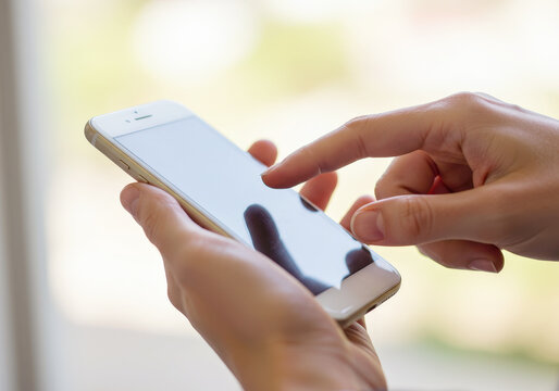 Hand operating a smartphone against a bright background