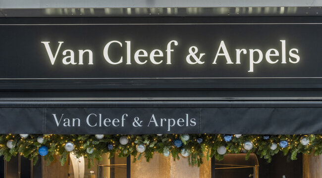 Geneva, Switzerland - December 15, 2024: signs and logotype of Van Cleef & Arpels offering a collection of fine jewelry, watches and perfumes on a shop window during the Christmas holidays